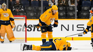 Nov 4, 2024; Nashville, Tennessee, USA;  Nashville Predators center Tommy Novak (82) lays face down after taking a puck to the face against the Los Angeles Kings during the third period at Bridgestone Arena. Mandatory Credit: Steve Roberts-Imagn Images