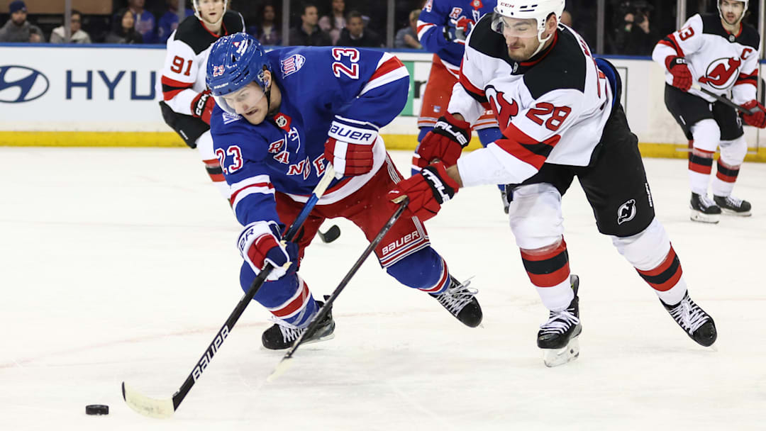 Mar 18, 2026; New York, New York, USA;  New York Rangers defenseman Adam Fox (23) and New Jersey Devils right wing Timo Meier (28) battle for control of the puck in the third period at Madison Square Garden. Mandatory Credit: Wendell Cruz-Imagn Images
