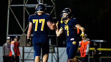 Iowa City Regina's Jackson Naeve, right, celebrates a touchdown with teammate Noah Clark (77) during a first round Class 1A high school football playoff game against Eddyville-Blakesburg-Fermont, Friday, Oct. 20, 2023, at Regina Catholic High School in Iowa City, Iowa.