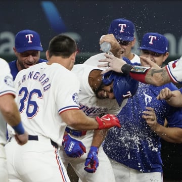 Aug 31, 2024; Arlington, Texas, USA; Texas Rangers center fielder Leody Taveras (3) is mobbed by teammates after hitting a walk-off single during the ninth inning against the Oakland Athletics at Globe Life Field. Mandatory Credit: Raymond Carlin III-USA TODAY Sports