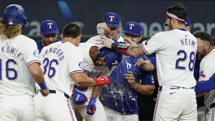 Aug 31, 2024; Arlington, Texas, USA; Texas Rangers center fielder Leody Taveras (3) is mobbed by teammates after hitting a walk-off single during the ninth inning against the Oakland Athletics at Globe Life Field. Mandatory Credit: Raymond Carlin III-USA TODAY Sports