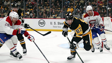 Nov 2, 2024; Pittsburgh, Pennsylvania, USA;  Pittsburgh Penguins center Sidney Crosby (87) clears the puck against Montreal Canadiens right wing Joel Armia (40) during the second period at PPG Paints Arena. Mandatory Credit: Charles LeClaire-Imagn Images