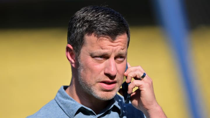 May 12, 2022; Los Angeles, California, USA; Los Angeles Dodgers president of baseball operations Andrew Friedman talks on his phone on the field before the game against the Philadelphia Phillies at Dodger Stadium. Mandatory Credit: Jayne Kamin-Oncea-USA TODAY Sports