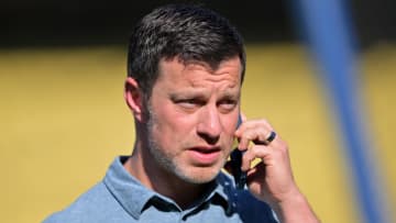 May 12, 2022; Los Angeles, California, USA; Los Angeles Dodgers president of baseball operations Andrew Friedman talks on his phone on the field before the game against the Philadelphia Phillies at Dodger Stadium. Mandatory Credit: Jayne Kamin-Oncea-USA TODAY Sports