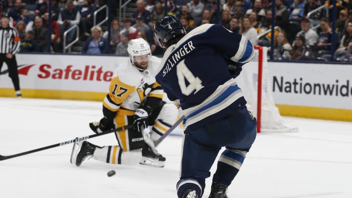 Mar 30, 2024; Columbus, Ohio, USA; Columbus Blue Jackets Forward Cole Sillinger (4) shoots as Pittsburgh Penguins right wing  Bryan Rust (17) drops to block during the first period at Nationwide Arena. Mandatory Credit: Russell LaBounty-USA TODAY Sports