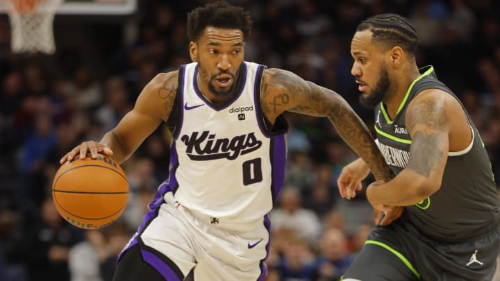 Mar 1, 2024; Minneapolis, Minnesota, USA; Sacramento Kings guard Malik Monk (0) works around Minnesota Timberwolves guard Monte Morris (23) in the first quarter at Target Center. Mandatory Credit: Bruce Kluckhohn-USA TODAY Sports