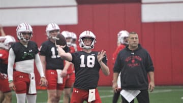 Wisconsin quarterback Braedyn Locke throws a pass as offensive coordinator Phil Longo watches during spring practice at the McClain Center in Madison, Wisconsin on Tuesday April 2, 2024.