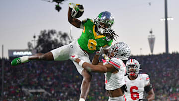 Jan 1, 2025; Pasadena, CA, USA;  Oregon Ducks running back Noah Whittington (6) runs against Ohio State Buckeyes cornerback Davison Igbinosun (1) in the second half in the 2025 Rose Bowl college football quarterfinal game at Rose Bowl Stadium. Mandatory Credit: Gary A. Vasquez-Imagn Images