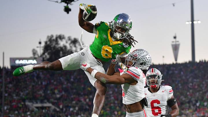 Jan 1, 2025; Pasadena, CA, USA;  Oregon Ducks running back Noah Whittington (6) runs against Ohio State Buckeyes cornerback Davison Igbinosun (1) in the second half in the 2025 Rose Bowl college football quarterfinal game at Rose Bowl Stadium. Mandatory Credit: Gary A. Vasquez-Imagn Images