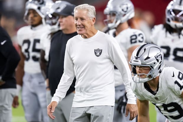 Pete Carroll smiling in front of Raiders players