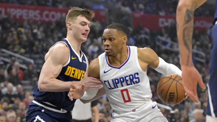 Apr 4, 2024; Los Angeles, California, USA;  Los Angeles Clippers guard Russell Westbrook (0) is defended by Denver Nuggets guard Christian Braun (0) in the first half at Crypto.com Arena. 