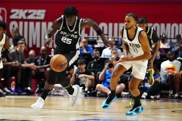 San Antonio Spurs guard Sidy Cissoko (25) dribbles ahead of Portland Trail Blazers guard Rayan Rupert (21). 