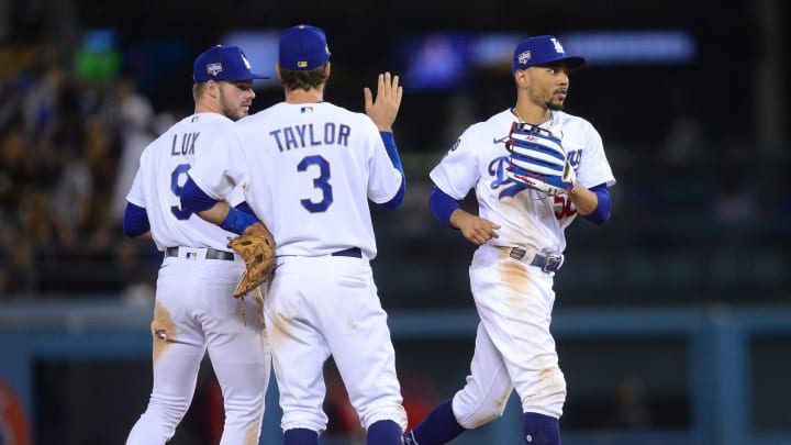 Jun 15, 2021; Los Angeles, California, USA; Los Angeles Dodgers right fielder Mookie Betts (50) shortstop Gavin Lux (9) and left fielder Chris Taylor (3) celebrate the 5-3 victory against the Philadelphia Phillies at Dodger Stadium. Mandatory Credit: Gary A. Vasquez-USA TODAY Sports