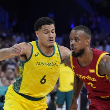 Jul 27, 2024; Villeneuve-d'Ascq, France; Spain guard Lorenzo Brown (2) drives past Australia small forward Josh Green (6) in men's Group A play during the Paris 2024 Olympic Summer Games at Stade Pierre-Mauroy. Mandatory Credit: John David Mercer-USA TODAY Sports