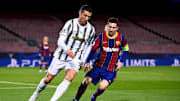Cristiano Ronaldo (L) of Juventus FC is challenged by Lionel...