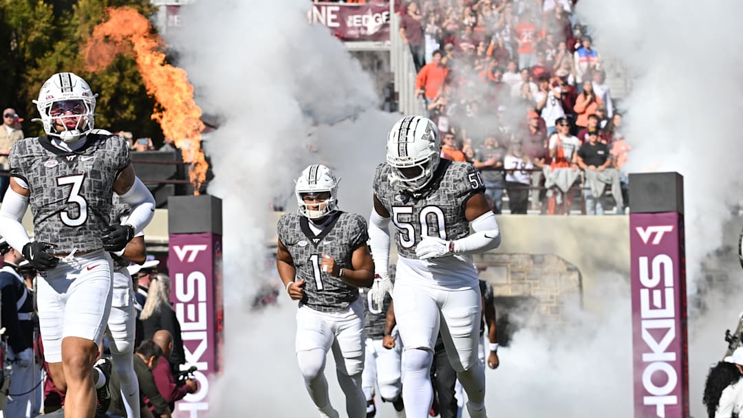 Nov 22, 2025; Blacksburg, Virginia, USA; Virginia Tech Hokies wide receiver Donavon Greene (3), Virginia Tech Hokies linebacker Darius Taylor (50) and Virginia Tech Hokies quarterback Kyron Drones (1) run into the stadium before the game at Lane Stadium. Mandatory Credit: Brian Bishop-Imagn Images