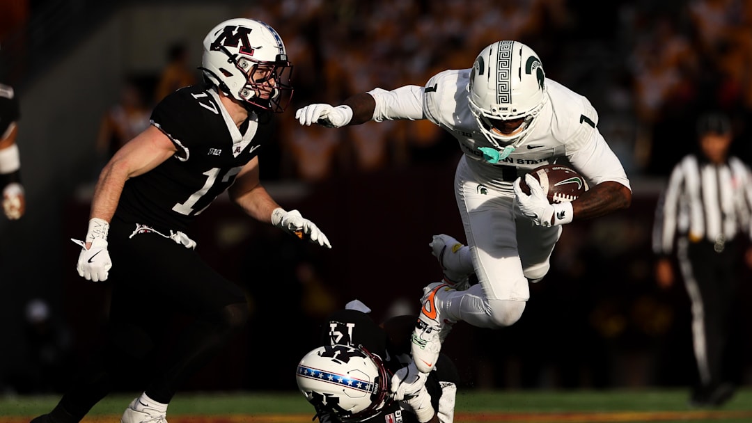 Nov 1, 2025; Minneapolis, Minnesota, USA; Michigan State Spartans wide receiver Omari Kelly (1) runs the ball as Minnesota Golden Gophers defensive back Kerry Brown (14) defends during the second half at Huntington Bank Stadium. Mandatory Credit: Matt Krohn-Imagn Images