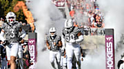 Nov 22, 2025; Blacksburg, Virginia, USA; Virginia Tech Hokies wide receiver Donavon Greene (3), Virginia Tech Hokies linebacker Darius Taylor (50) and Virginia Tech Hokies quarterback Kyron Drones (1) run into the stadium before the game at Lane Stadium. Mandatory Credit: Brian Bishop-Imagn Images