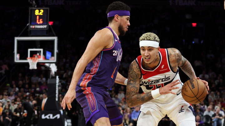 Dec 17, 2023; Phoenix, Arizona, USA; Washington Wizards forward Kyle Kuzma (33) dribbles the ball against Phoenix Suns guard Devin Booker (1) during the first half at Footprint Center. Mandatory Credit: Zachary BonDurant-USA TODAY Sports