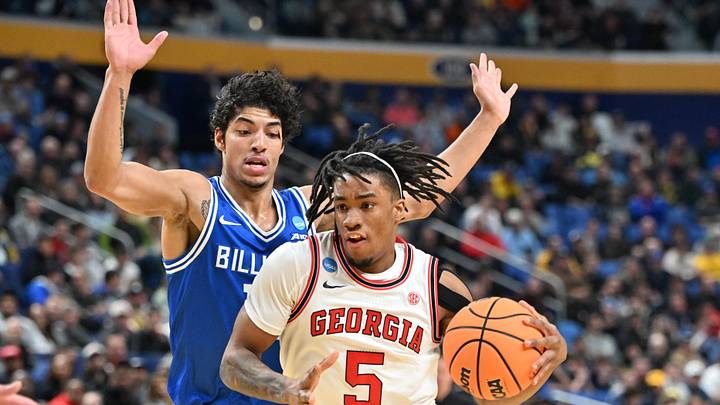 Mar 19, 2026; Buffalo, NY, USA; Georgia Bulldogs guard Jeremiah Wilkinson (5) drives to the basket against Saint Louis Billikens guard Dion Brown (13) during the first half of a first round game of the men's 2026 NCAA Tournament at Keybank Center. Mandatory Credit: Mark Konezny-Imagn Images
