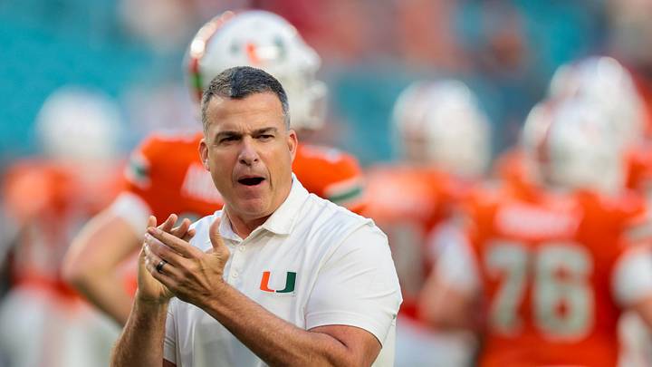 Oct 17, 2025; Miami Gardens, Florida, USA; Miami Hurricanes head coach Mario Cristobal works with his players before the game against the Louisville Cardinals at Hard Rock Stadium. Mandatory Credit: Sam Navarro-Imagn Images