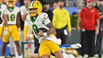 Sep 28, 2024; Pasadena, California, USA; Oregon Ducks quarterback Dillon Gabriel (8) runs past UCLA Bruins linebacker Carson Schwesinger (49) during the second quarter at Rose Bowl. Mandatory Credit: Robert Hanashiro-Imagn Images