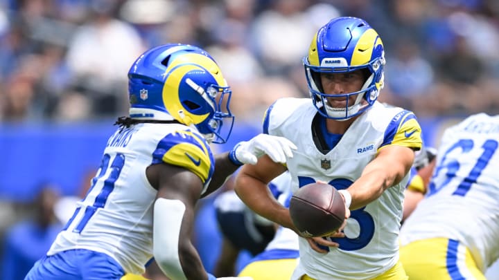 Aug 11, 2024; Inglewood, California, USA; Los Angeles Rams quarterback Stetson Bennett (13) passes the ball to running back Zach Evans (21) against the Dallas Cowboys during the first quarter at SoFi Stadium. Mandatory Credit: Jonathan Hui-USA TODAY Sports