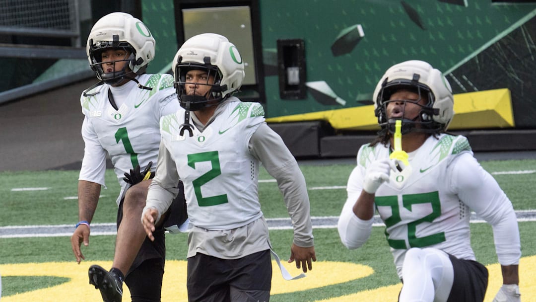 Oregon’s Dakorien Moore, left, Gary Bryant Jr. and Jay Harris work out during practice at Autzen Stadium in Eugene Dec. 14, 2025 before the first-round CFP game against James Madison.