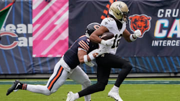 Oct 19, 2025; Chicago, Illinois, USA; New Orleans Saints wide receiver Chris Olave (12) runs with the ball after making a catch against Chicago Bears cornerback Kyler Gordon (6) during the first half at Soldier Field. Mandatory Credit: David Banks-Imagn Images