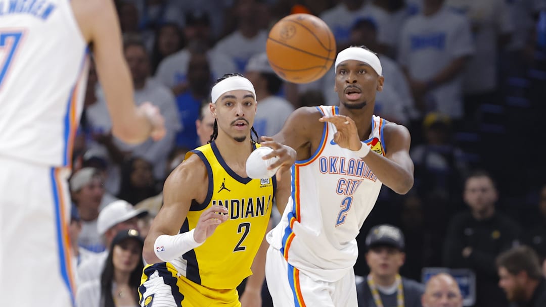 Oklahoma City Thunder guard Shai Gilgeous-Alexander passes the ball by Indiana Pacers guard Andrew Nembhard during Game One of the 2025 NBA Finals at Paycom Center. 