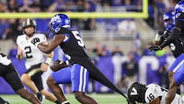 Linebacker D'Eryk Jackson (54) of the Kentucky Wildcats intercepts this pass in the first half as tight end Cole Spence (16) of the Vanderbilt Commodores tries to stop him with a grip on Jackson's shirt Saturday, Oct. 12, 2024 in Lexington, Ky.