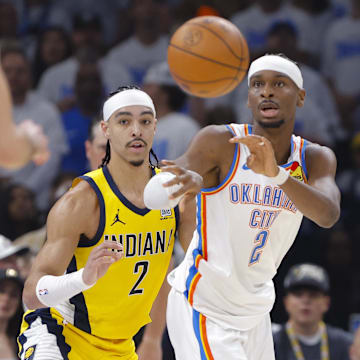 Oklahoma City Thunder guard Shai Gilgeous-Alexander passes the ball by Indiana Pacers guard Andrew Nembhard during Game One of the 2025 NBA Finals at Paycom Center. 