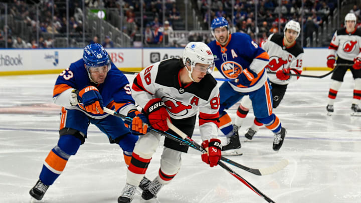 Jan 6, 2026; Elmont, New York, USA;  New York Islanders center Casey Cizikas (53) defends against New Jersey Devils center Jack Hughes (86) during the third period at UBS Arena. Mandatory Credit: Dennis Schneidler-Imagn Images