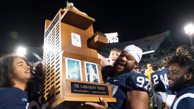 Penn State football players lift up the Land-Grant Trophy after defeating Michigan State, 35-16, at Beaver Stadium.