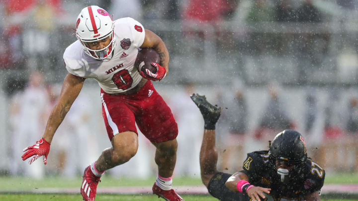 Dec 16, 2023; Orlando, FL, USA;  Miami (OH) Redhawks running back Rashad Amos (0) breaks a tackle from Appalachian State Mountaineers safety Ronald Clarke (27) in the first quarter during the Avocados from Mexico Cure Bowl at FBC Mortgage Stadium. Mandatory Credit: Nathan Ray Seebeck-USA TODAY Sports