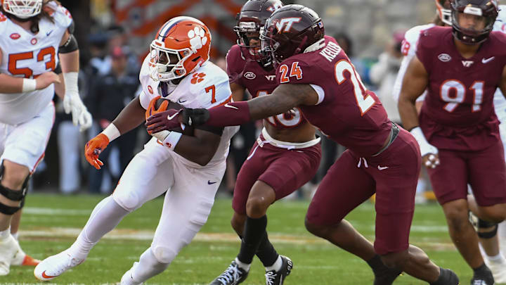 Nov 9, 2024; Blacksburg, Virginia, USA;  Clemson Tigers running back Phil Mafah (7) runs the ball as Virginia Tech Hokies linebacker Jaden Keller (24) reaches for the tackle during the second quarter at Lane Stadium. Mandatory Credit: Brian Bishop-Imagn Images