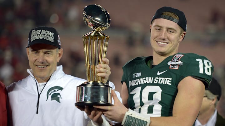 Jan 1, 2014; Pasadena, CA, USA; Michigan State Spartans coach Mark Dantonio (left) and quarterback Connor Cook (18) hoist the Leishman Trophy after the 100th Rose Bowl against the Stanford Cardinal. Michigan State defeated Stanford 24-20. Mandatory Credit: Kirby Lee-Imagn Images