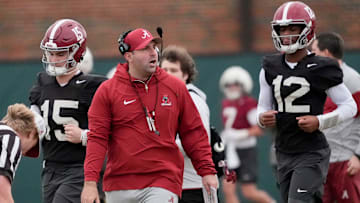 Quarterbacks coach Nick Seridan walks between quarterbacks Ty Simpson (15) and Keelon Russell (12)