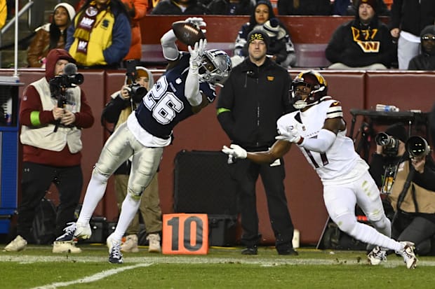 Dallas Cowboys cornerback DaRon Bland intercepts a pass intended for Washington Commanders wide receiver Terry McLaurin.