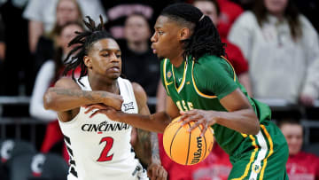 Cincinnati Bearcats guard Jizzle James (2) defends on San Francisco Dons forward Jonathan Mogbo (10) in the first half of a college basketball game in the National Invitation Tournament, Wednesday, March 20, 2024, at Fifth Third Arena in Cincinnati.