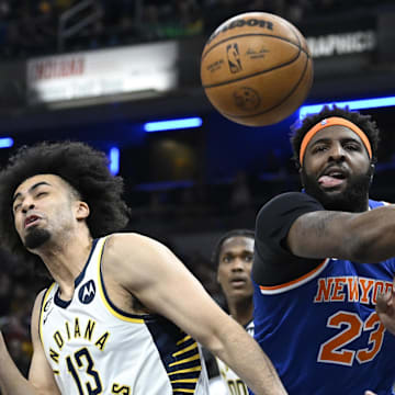 Apr 5, 2023; Indianapolis, Indiana, USA;  New York Knicks center Mitchell Robinson (23) knocks a rebound away from Indiana Pacers forward Jordan Nwora (13) during the first half at Gainbridge Fieldhouse. Mandatory Credit: Marc Lebryk-Imagn Images