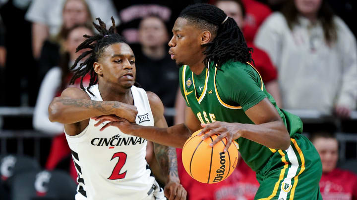 Cincinnati Bearcats guard Jizzle James (2) defends on San Francisco Dons forward Jonathan Mogbo (10) in the first half of a college basketball game in the National Invitation Tournament, Wednesday, March 20, 2024, at Fifth Third Arena in Cincinnati.