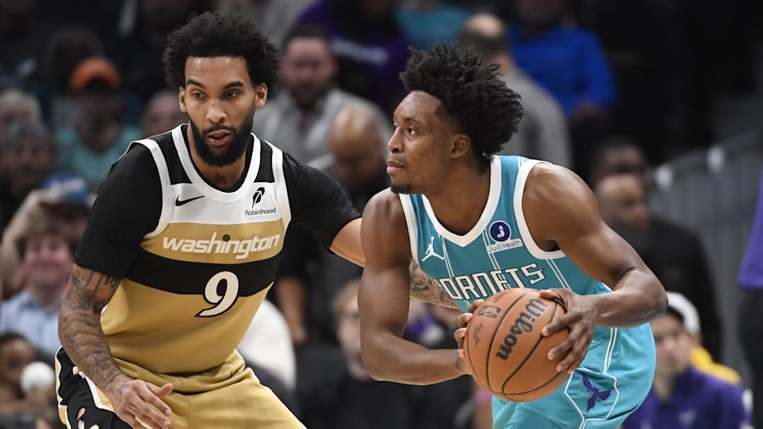 Dec 23, 2025; Charlotte, North Carolina, USA;  Charlotte Hornets guard Collin Sexton (8) looks to pass as he is defended by Washington Wizards forward Justin Champagnie (9) during the first half at the Spectrum Center. Mandatory Credit: Sam Sharpe-Imagn Images