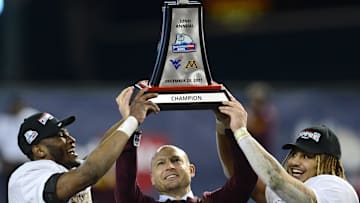Dec 28, 2021; Phoenix, AZ, USA; Minnesota Golden Gophers head coach P. J. Fleck (center) celebrates with the trophy alongside players Tyler Nubin (left) and Ky Thomas (right) after defeating the West Virginia Mountaineers at Chase Field. Mandatory Credit: Joe Camporeale-Imagn Images
