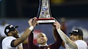 Dec 28, 2021; Phoenix, AZ, USA; Minnesota Golden Gophers head coach P. J. Fleck (center) celebrates with the trophy alongside players Tyler Nubin (left) and Ky Thomas (right) after defeating the West Virginia Mountaineers at Chase Field. Mandatory Credit: Joe Camporeale-Imagn Images