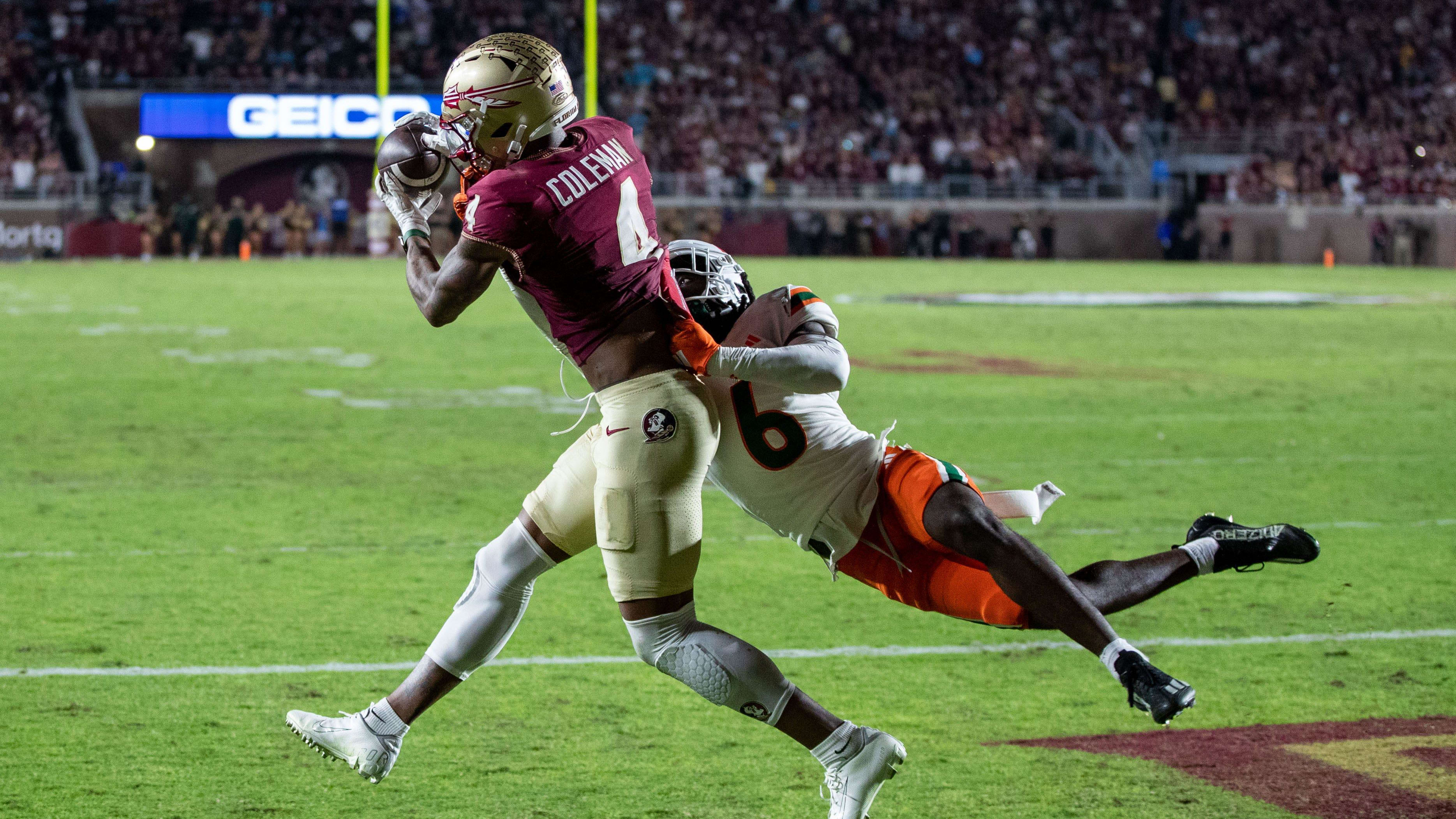 Florida State Seminoles wide receiver Keon Coleman (4) catches a pass while draped in coverage.