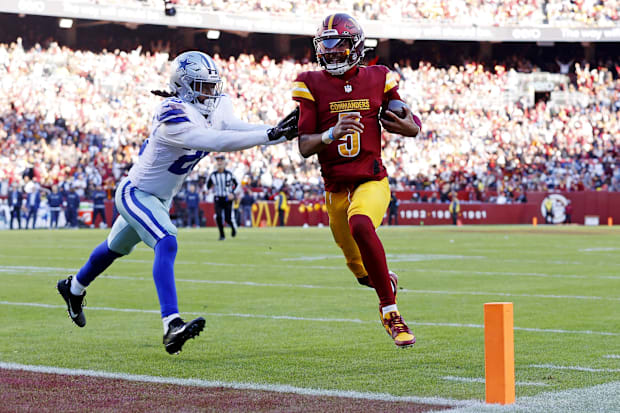 Washington Commanders quarterback Jayden Daniels runs for a touchdown against Dallas Cowboys safety Malik Hooker.