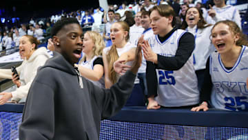 AJ Dybantsa high-fives fans at a BYU game.