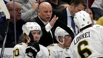 Mar 4, 2024; Toronto, Ontario, CAN; Boston Bruins head coach Jim Montgomery talks to defenseman Mason Lohrei (6) during a break in the action against the Toronto Maple Leafs during the second period at Scotiabank Arena. Mandatory Credit: John E. Sokolowski-Imagn Images
