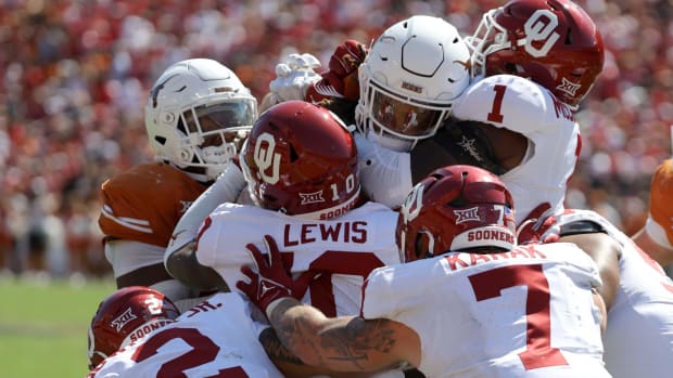 Oklahoma Sooners Billy Bowman, Kip Lewis, Jaren Kanak and Dasan McCullough stop Texas Longhorns running back Jonathon Brooks